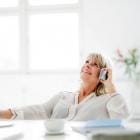 gelukkige, volwassen zakenvrouw aan het bellen op haar bureau