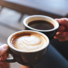 Twee tassen koffie waarvan de ene zwart en de andere met melkschuim.