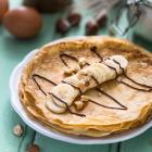 stapel pannenkoeken met banaan, chocolade en noten.