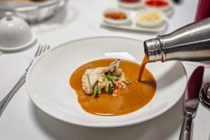 Pouring the lobster bisque into the bowl.