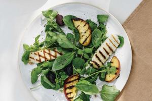 Salade van gegrilde perzik, basilicum, halloumi en zwarte olijven