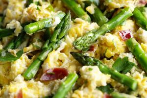 Groene asperges met roerei, rauwe ham en bruine boter