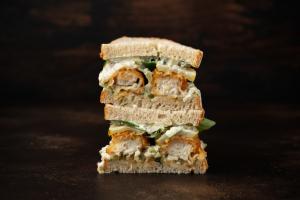 Sandwich met verse zalm, gedroogde rauwe ham, spinazie en bieslook-yoghurtdressing