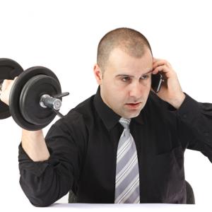 Adult business man on the phone doing fitness at work