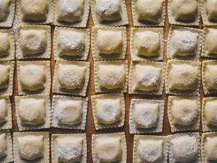 Raw traditional Italian ravioli with flour,Basil,Egg,And salt on a wooden board