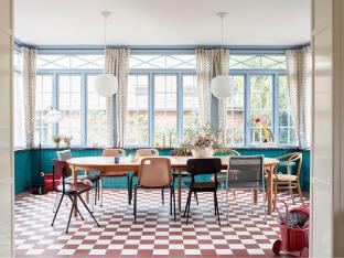 De eetkamer zit in de nieuwe uitbouw. Rond de vintage eettafel van Deens designer Børge Mogensen staan schoolstoelen van Hay. De exemplaren in metaaldraad zijn Italiaans en kocht Nicolaj van een restaurant.