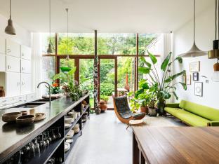 De volumineuze uitbouw van de rijwoning ontwierp Karolien zelf. Zeven meter brede raampartijen geven uit op de grote groene tuin.