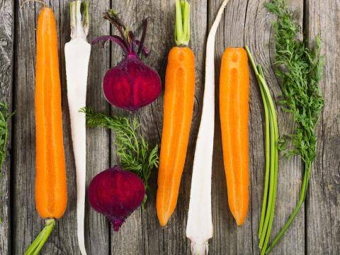 sliced raw vegetables: carrot, turnip, beetroot and parsley on old wooden table background; Shutterstock ID 333954770