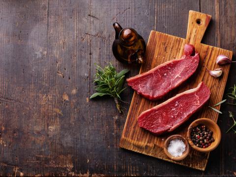 Raw fresh meat Striploin steak and seasoning on dark wooden background; Shutterstock ID 226371031