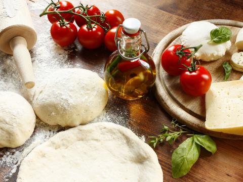 Italiaanse pizzabakker is acrobaat met pizzadeeg