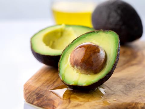 ripe avocado cut in half on a wooden table