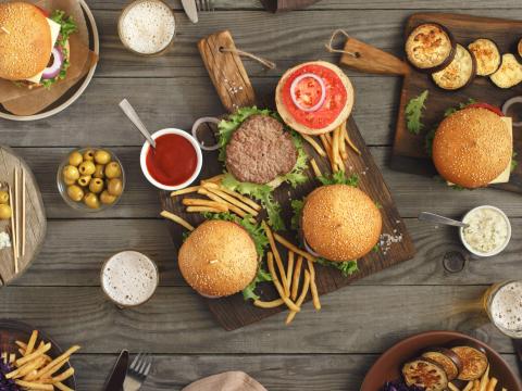 Different food on a wooden table, burgers, fries, grilled eggplant, different sauces, roquefort cheese, olives and light beer, top view. Outdoors food Concept; Shutterstock ID 432365551; Projectnummer: B09773 ; Uitgave: Libelle Lekker; Traffic: Rien Delvaux; Anders: /