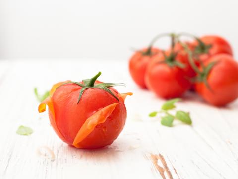 Tomato with purified skin and a bunch of tomatoes on white background. Background image.; Shutterstock ID 640978237; Projectnummer: B09773 ; Uitgave: Libelle Lekker; Traffic: Rien Delvaux; Anders: /