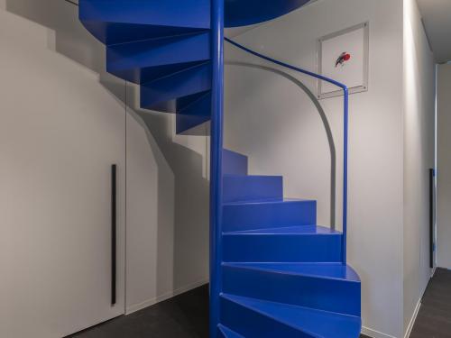 De typerende huiskleur Bleu Outremer herhaalt zich in de nachtzone met de wenteltrap, als wandkleur in de kinderkamer en in de originele Les Couleurs® Le Corbusier Jung-lichtschakelaars.© Pieter Clicteur