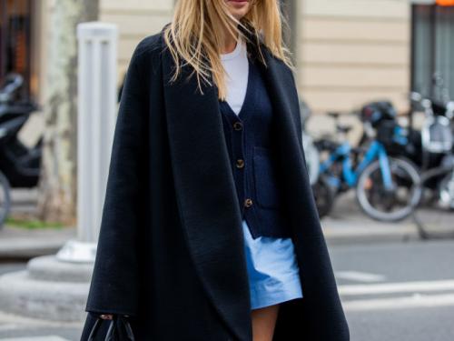 PARIS, FRANCE - OCTOBER 01: Camille Charriere is seen wearing black coat, blue shorts, cardigan, white shirt, black bag, boots outside Loewe during Paris Fashion Week - Womenswear Spring Summer 2022 on October 01, 2021 in Paris, France. (Photo by Christian Vierig/Getty Images)