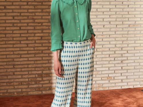 Retro ruchesBloes met ruches aan de kraag (89,99 euro) en pantalon met grafisch motief in wit-blauw-groen (109,99 euro), van Imprévu.