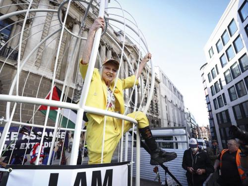 Vivienne Westwood in een gigantische vogelkooi met het opschrift 'I am Julian Assange'