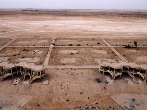This picture shows abandoned hotels and tourist facilities in Iraq's Sawa Lake which is completely dry due to climate change and rising temperature, in the country's southern province of al-Muthanna on April 19, 2022. - In Sawa, a sharp drop in rainfall -- now only at 30 percent of what used to be normal for the region -- has lowered the underground water table, itself drained by wells, said a senior advisor at Iraq's water resources ministry. (Photo by Asaad NIAZI / AFP)