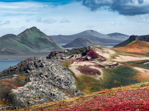 Panoramic landscape view of colorful rainbow volcanic Landmannalaugar mountains, volcanoes, lava fields, crater, water streams and lagoons at blue sky with clouds, Iceland, summer