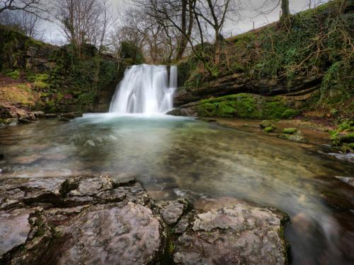 Janet's Foss is a small waterfall in the vicinity of the village of Malham in the Yorkshire Dales National Park Yorkshire. It carries Gordale Beck, a river, over a limestone outcrop topped by tufa into a deep plunge  pool below. The pool was traditionally used for sheep dipping, an event which took on a carnival air and drew the village inhabitants for the social occasion.