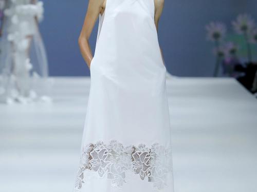 Moderne romantiekEenvoudige, mouwloze jurk met detail in bloemenkant, van Jesus Peiro (prijs op aanvraag).