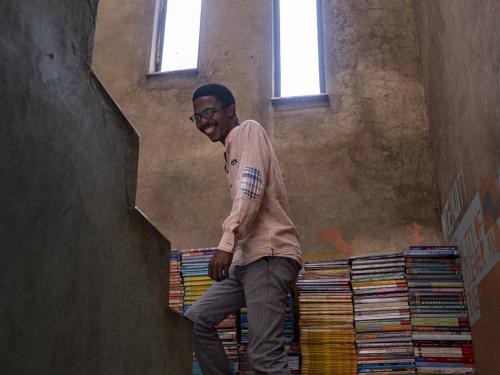 Founder of the Soweto Book Café, Thami Mazibuko, 36, walks up the stairs of his home in Soweto on April 5, 2022. - In Thami Mazibuko's childhood home, the 36-year-old has turned the upper level into a bookstore and library, seeded with 30 of his own books, now overflowing with hundreds of donations.
After he finished school, he left Soweto and moved into the formerly white suburbs of Johannesburg, where he stayed with relatives who were artists, with a home full of books.
He developed an insatiable appetite for reading, even bring books into the reggae club where liked to listen to music.
When he decided to move back home, he brought his growing personal collection with him.
So began the Soweto Book Cafe, officially founded in 2018. (Photo by EMMANUEL CROSET / AFP)