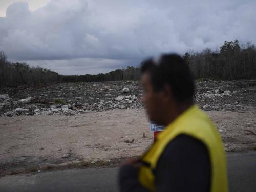 A security guard walks at the construction site of Section 5 South of the Mayan Train between the resorts of Playa del Carmen and Tulum which was halted by a district judge pending resolution of an injunction sought by scuba divers and environmentalists -- in the jungle in Playa del Carmen, Quintana Roo State, Mexico, on April 26, 2022. - A Mexican judge earlier this month suspended construction of part of President Andres Manuel Lopez Obrador's flagship tourist train project in the Yucatan peninsula due to a lack of environmental impact studies. The Mayan Train, a roughly 1,500-kilometre (950 mile) rail loop linking popular Caribbean beach resorts and archeological ruins, has met with opposition from environmentalists and indigenous communities. (Photo by Pedro PARDO / AFP)