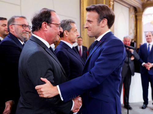 France's former President Francois Hollande (L) congratulates French President Emmanuel Macron after he is sworn-in for a second term as president following his re-election on April 14, during a ceremony at the Elysee Palace in Paris, on May 7, 2022. (Photo by GONZALO FUENTES / POOL / AFP)