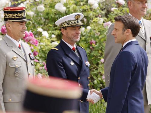 Emmanuel Macron (R) shakes hands with French Army chief of staff General Thierry Burkhard (L) and French admiral Jean-Philippe Rolland (C) chief of the particular staff of French president as he reviews troops at the Elysee presidential palace in Paris on May 7, 2022, during his investiture ceremony as French President, following his re-election last April 24. (Photo by Ludovic MARIN / AFP)