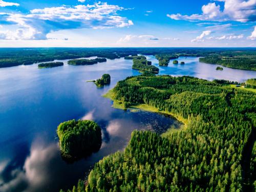 Aerial view of blue lakes and green forests on a sunny summer day in Finland. Drone photography from above