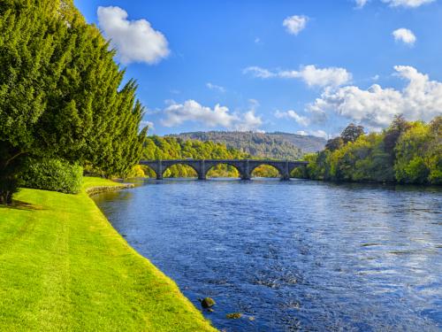 Bend in the River Tay, the longest river in Scotland at Dunkeld with Thomas Telford designed bridge. Taken in autumn on a sunny day with grass and foliage still vivid green.