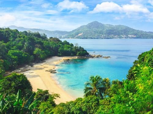 Exotic views through the jungle to uninhabited beach. Blue lagoon. Picturesque bay. Laem sing beach.