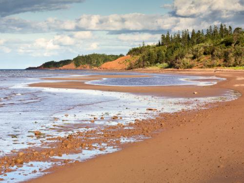 Red sand beach and cloudy sky near Beach Point (Prince Edward Island, Canada).