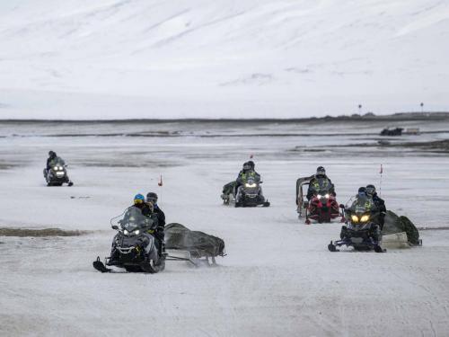 (FILES) In this file photo taken on May 08, 2022 Tourists come back to Longyearbyen after a tour on snow mobiles, on May 8, 2022, on Spitsbergen island, in Svalbard Archipelago, northern Norway. - Home to polar bears, the midnight sun and the northern lights, a Norwegian archipelago perched high in the Arctic is trying to find a way to profit from its pristine wilderness without ruining it. The Svalbard archipelago, located 1,300 kilometres (800 miles) from the North Pole and reachable by commercial airline flights, offers visitors vast expanses of untouched nature, with majestic mountains, glaciers and frozen fjords. Or, the fjords used to be frozen. Svalbard is now on the frontline of climate change, with the Arctic warming three times faster than the planet. (Photo by Jonathan NACKSTRAND / AFP)