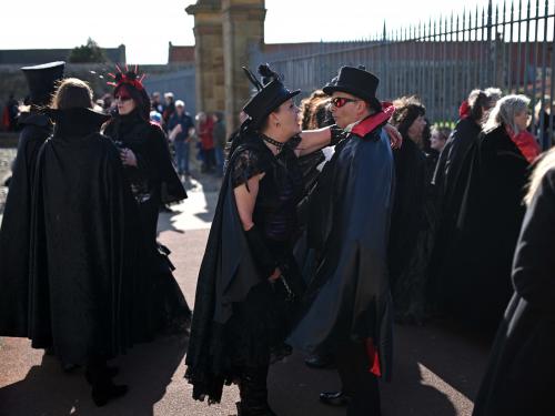 Vampires wait in the grounds of Whitby Abbey during a Guinness world record attempt to gather the largest number of vampires together in one place, in Whitby, north-east England on May 26, 2022. - The world record attempt takes place on the 125th anniversary of the first publication of Bram Stoker's novel 'Dracula'. Stoker visited Whitby in 1890 and it's understood that the town and 13th century gothic ruins of the Abbey provided inspiration for Dracula. The current record saw 1039 vampires gather at Doswell in Virginia, USA in 2011. (Photo by Oli SCARFF / AFP)