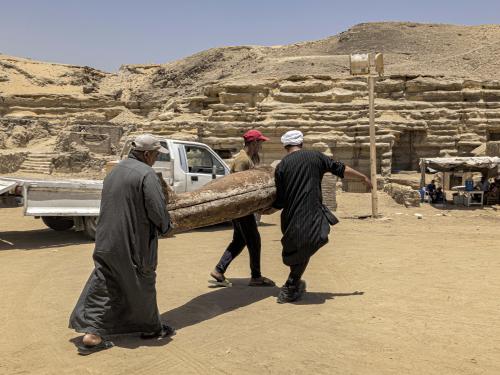 One of the sarcophaguses found in a cache dating to the Egyptian Late Period (around the fifth century BC) is transported after its discovery by a mission headed by Egypt's Supreme Council of Antiquities, at the Bubastian cemetery at the Saqqara necropolis, southwest of Egypt's capital on May 30, 2022. - Egypt on May 30 unveiled a cache of 150 bronze statues depicting various gods and goddesses including "Bastet, Anubis, Osiris, Amunmeen, Isis, Nefertum and Hathor," along with 250 sarcophagi at the Saqqara archaeological site south of Cairo, the latest in a series of discoveries in the area. (Photo by Khaled DESOUKI / AFP)