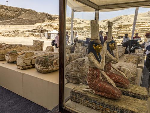 Statuettes depicting the Egyptian goddesses (L to R) Isis (Iset) and Nephthys (Nebet-Het) and other sarcophaguses found in a cache dating to the Egyptian Late Period (around the fifth century BC) are displayed after their discovery by a mission headed by Egypt's Supreme Council of Antiquities, at the Bubastian cemetery at the Saqqara necropolis, southwest of Egypt's capital on May 30, 2022. - Egypt on May 30 unveiled a cache of 150 bronze statues depicting various gods and goddesses including "Bastet, Anubis, Osiris, Amunmeen, Isis, Nefertum and Hathor," along with 250 sarcophagi at the Saqqara archaeological site south of Cairo, the latest in a series of discoveries in the area. (Photo by Khaled DESOUKI / AFP)