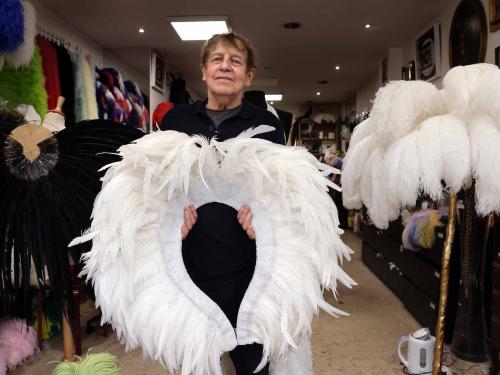 Dominique De Roo, official feather craftsman of the Lido poses inside his workshop in Paris on June 1, 2022. - The Lido cabaret, an institution for Parisian night life since 1889, is set to lay off 157 of 184 employees, including its "Bluebell girls" troupe of dancers, announced the new owner, French hotels giant Accor. (Photo by Thomas COEX / AFP)