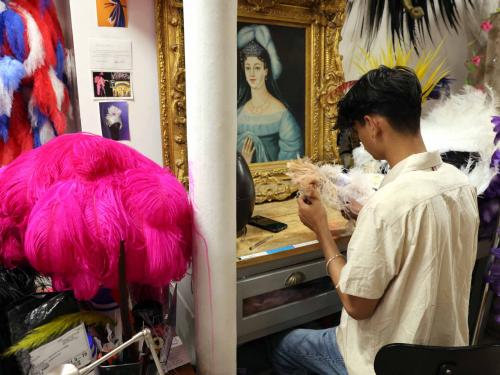 Nepalese artist Susan Gurung, assistant of Dominique De Roo, official feather craftsman of the Lido cabaret, works on feathers used for costumes, inside the workshop, in Paris on June 1, 2022. - The Lido cabaret, an institution for Parisian night life since 1889, is set to lay off 157 of 184 employees, including its "Bluebell girls" troupe of dancers, announced the new owner, French hotels giant Accor. (Photo by Thomas COEX / AFP)