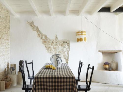 La salle à manger abrite des céramiques signées par Brigitte Penicaud, une artiste du village voisin. Le plafonnier à pois ocres, lui, est une réalisation d’OSH maison artisanale.