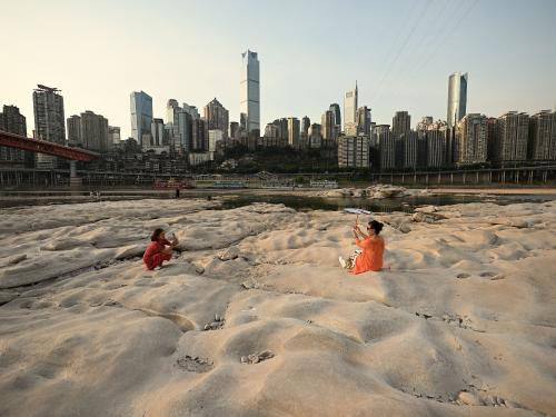 TOPSHOT - People are seen at the dried-up riverbed of the Jialing river, a tributary of the Yangtze River in China's southwestern city of Chongqing on August 25, 2022. (Photo by Noel Celis / AFP) (Photo by NOEL CELIS/AFP via Getty Images)