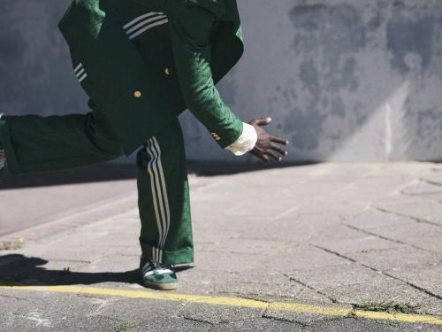 Groen pak en suède sneakers Gazelle, Gucci x Adidas. Zijden hemd en rolkraagtruitje met jacquardprint, Prada.