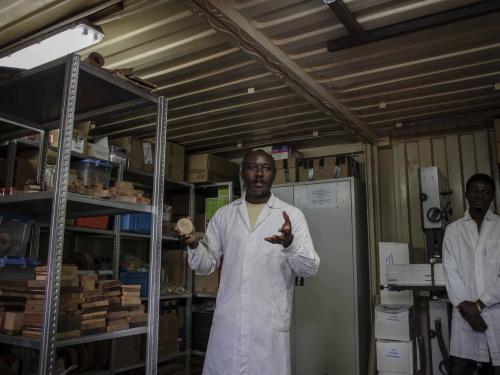 Nestor Luambua (L), who is in charge of the wood laboratory, explains how the laboratory works in Yangambi, 100 km from the city of Kisangani, in the Tshopo province, northeast of the Democratic Republic of Congo, on September 2, 2022. - The site, renowned during the time of Belgian colonisation for its research in tropical agronomy, hosts a herbarium that has more than 6000 species. (Photo by Guerchom Ndebo / AFP)