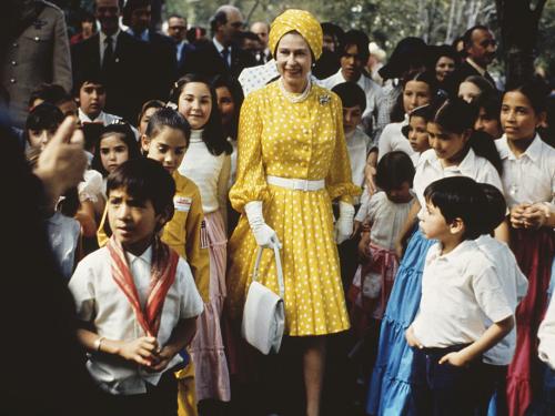 Queen Elizabeth II with a group of local children during her state visit to Mexico, February-March 1975. (Photo by Serge Lemoine/Hulton Archive/Getty Images)