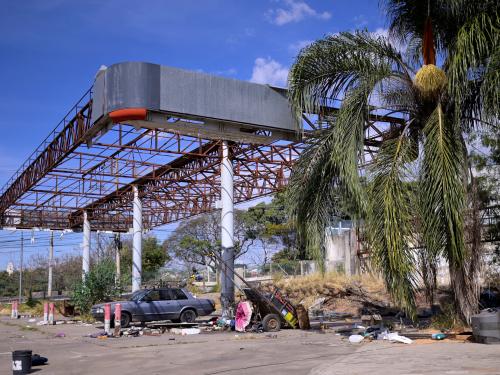 This photograph taken on August 24, 2022 in Belo Horizonte, Minas Gerais state, Brazil, shows an abandoned petrol station where a man has lived for over 10 years. - A vintage pump in the Vietnamese hills; a Madrid petrol station topped with a giant sombrero; a multi-coloured futuristic fuel outlet in Dubai  whatever its form the humble filling stop, emblem of our modern societies, would appear to be running out of road. (Photo by DOUGLAS MAGNO / AFP)