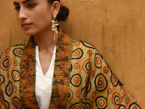 Vergulde oorringen (245 euro), kimono (475 euro) en bloes (185 euro), van Christine Bekaert.