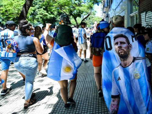 BUENOS AIRES, ARGENTINA - DECEMBER 20: Fans of Argentina wear flags with the image of Lionel Messi as they gather for the victory parade of the Argentina men's national football team after winning the FIFA World Cup Qatar 2022 on December 20, 2022 in Buenos Aires, Argentina. (Photo by Marcelo Endelli/Getty Images)