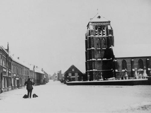 Zo te zien was er in de winter van 1930 nogal wat sneeuw gevallen. Op de verlaten dorpsplaats loop Jozef Deberdt met zijn juk en petroleum ketels om zijn klanten van brandstof voor hun lampen en petroleumvuurtjes te voorzien.