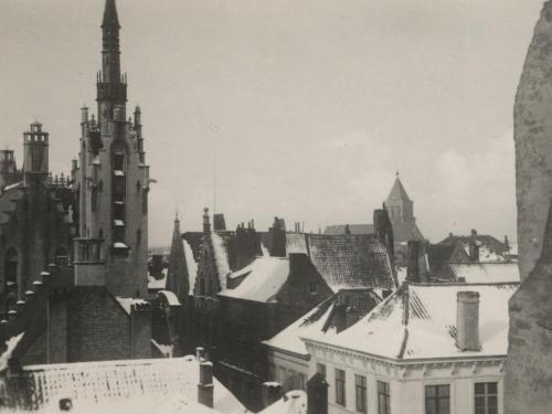 Brugse daken in de sneeuw in 1937 met links de Poortersloge en rechts op de achtergrond de Sint-Jakobskerk.