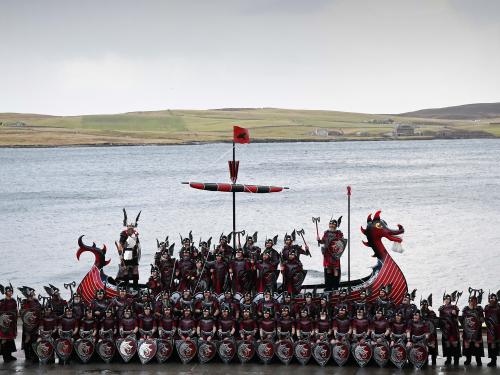 Members of the Up Helly Aa 'Jarl Squad' pose for photographs with their Viking galley ship in Lerwick, Shetland Islands on January 31, 2023 before the Up Helly Aa festival later in the day. - Up Helly Aa celebrates the influence of the Scandinavian Vikings in the Shetland Islands and culminates with up to 1,000 'guizers' (men in costume) throwing flaming torches into their Viking longboat and setting it alight later in the evening. (Photo by Andy Buchanan / AFP)